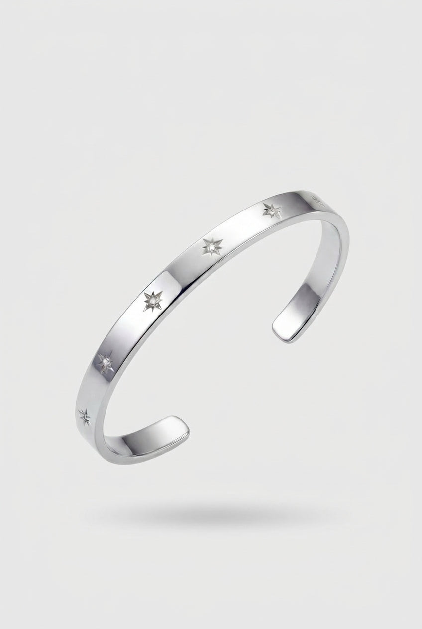 Silver bracelet with engraved stars on a light gray background
