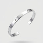 Silver bracelet with engraved stars on a light gray background