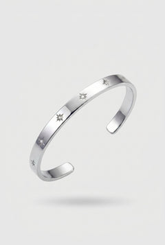 Silver bracelet with engraved stars on a light gray background