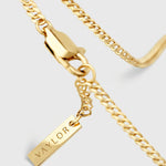 Gold chain necklace with a tag pendant on a light gray background