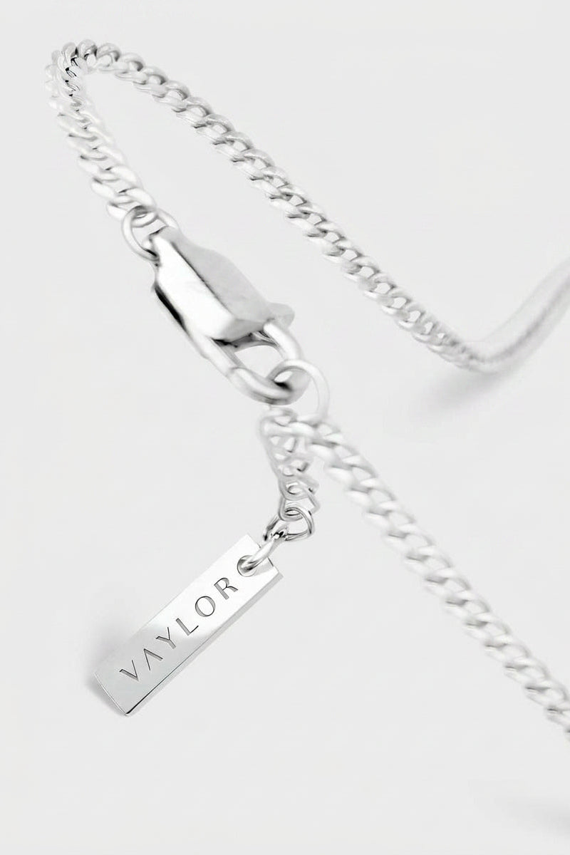 Silver chain necklace with a pendant on a white background