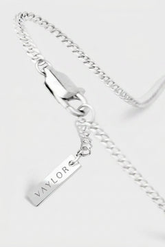 Silver chain necklace with a pendant on a white background