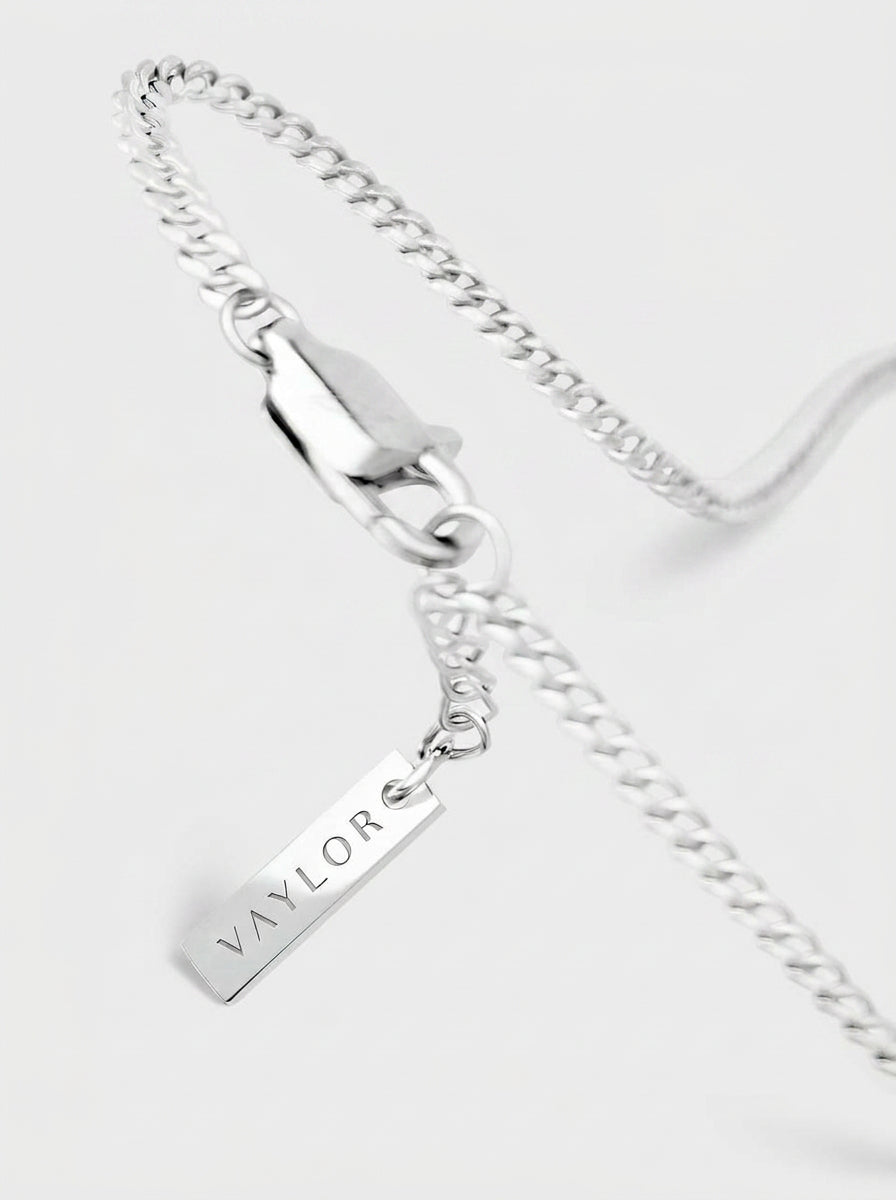 Silver chain necklace with a pendant on a white background