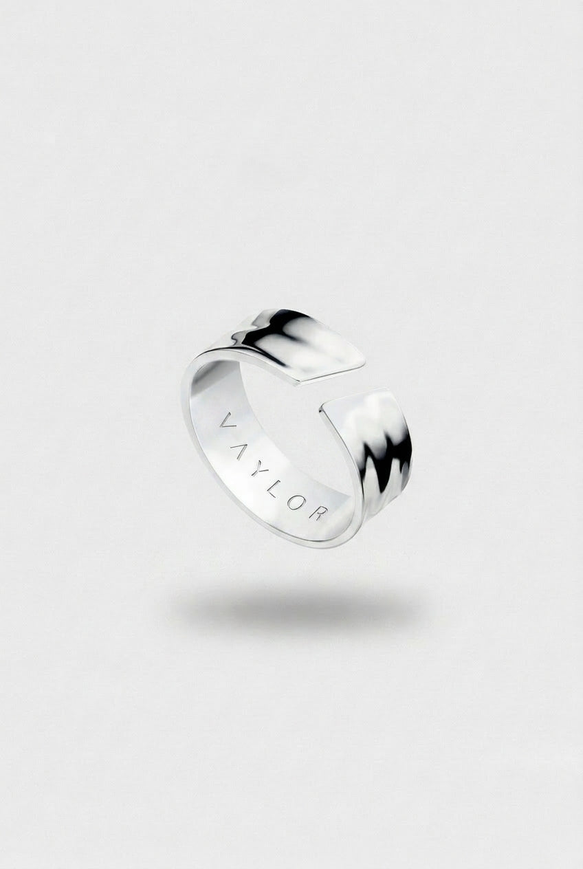 Silver ring with 'VAYLOR' engraving on the inside on a light gray background