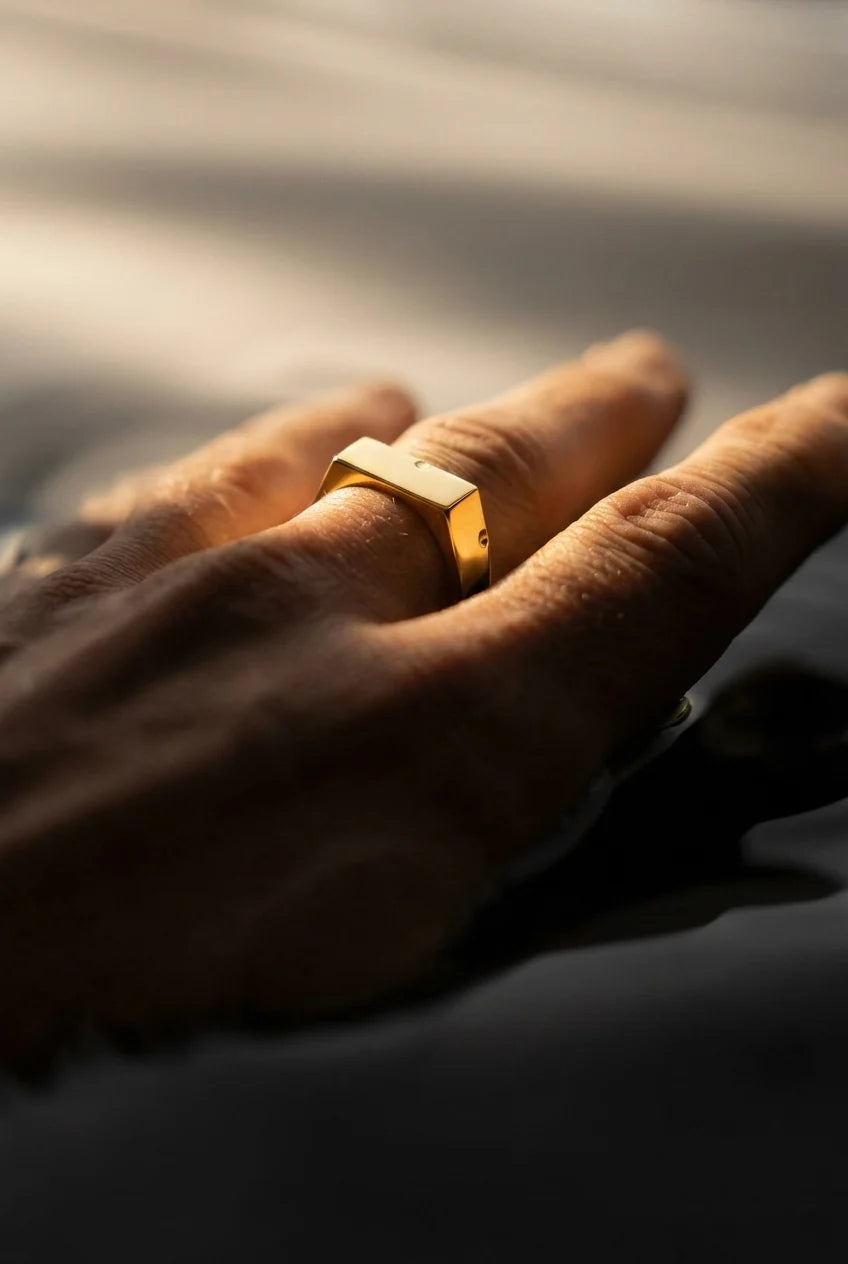 Gold ring on a person's finger with a blurred background