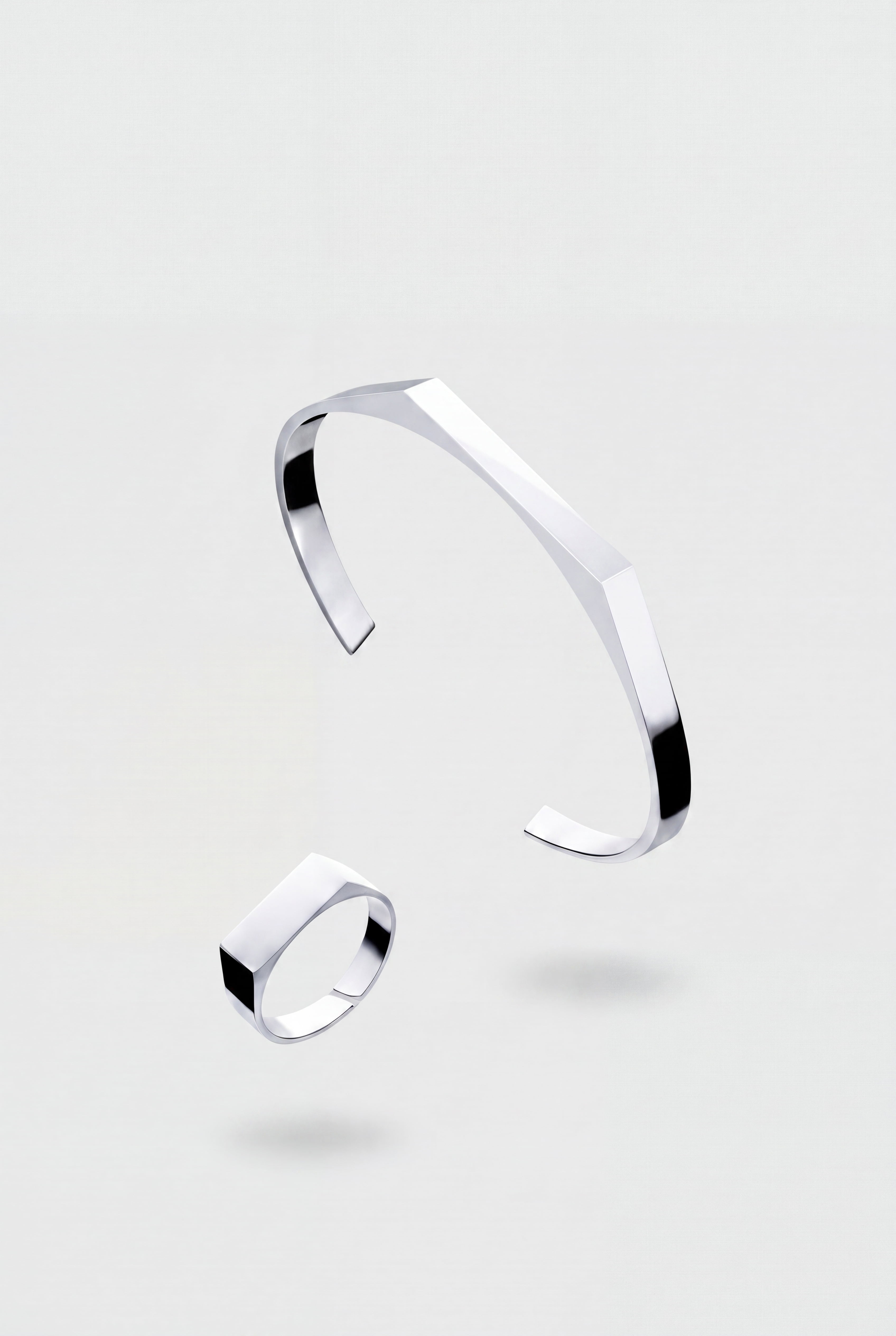 Zilveren armband- en ringset op een lichtgrijze achtergrond