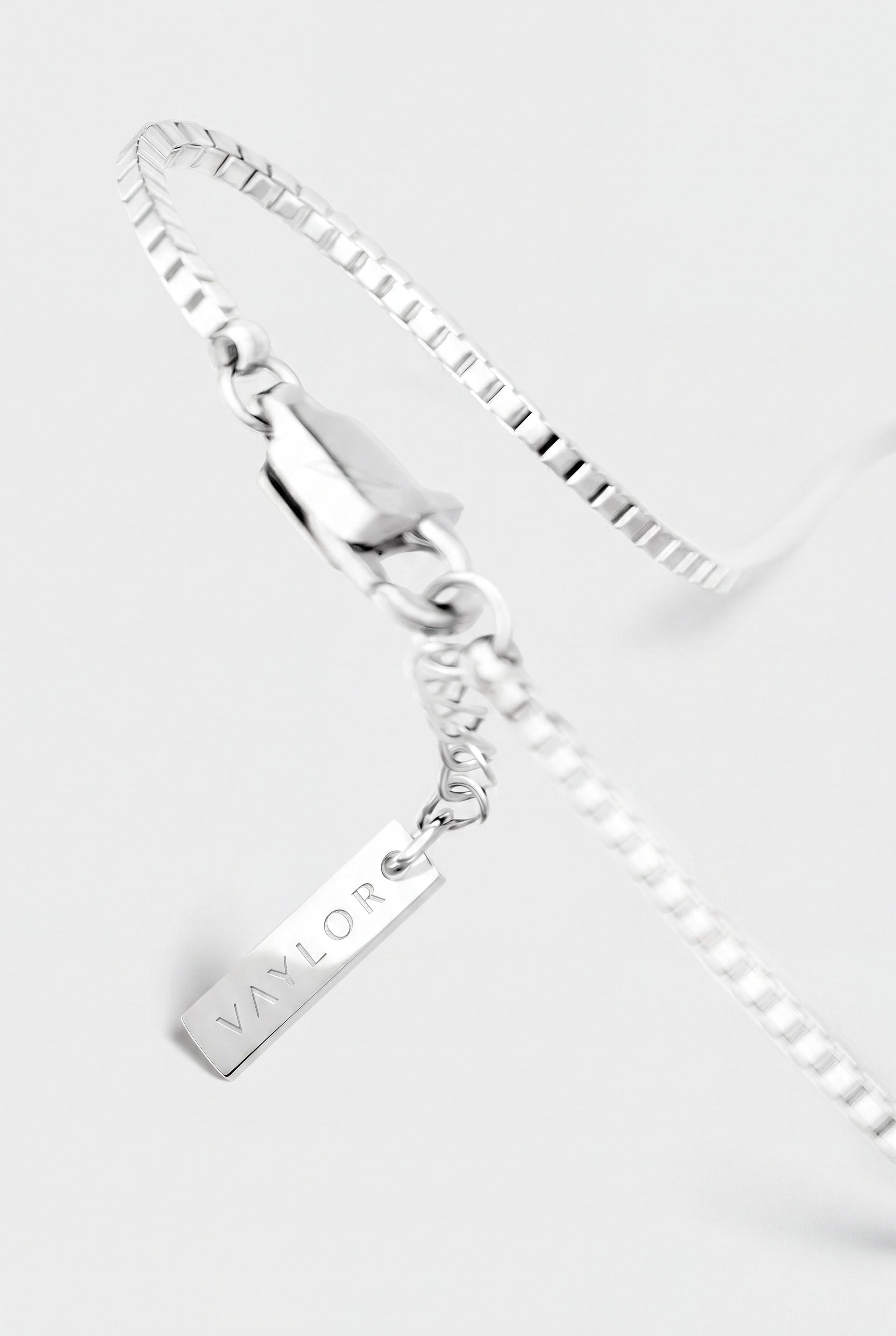 Silver bracelet with a tag on a white background