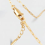 Gold bracelet with a tag on a light gray background