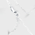 Silver bracelet with a tag on a light gray background