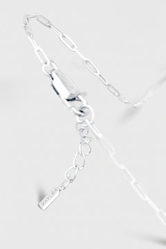 Silver bracelet with a tag on a light gray background