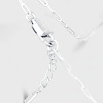 Silver bracelet with a tag on a light gray background