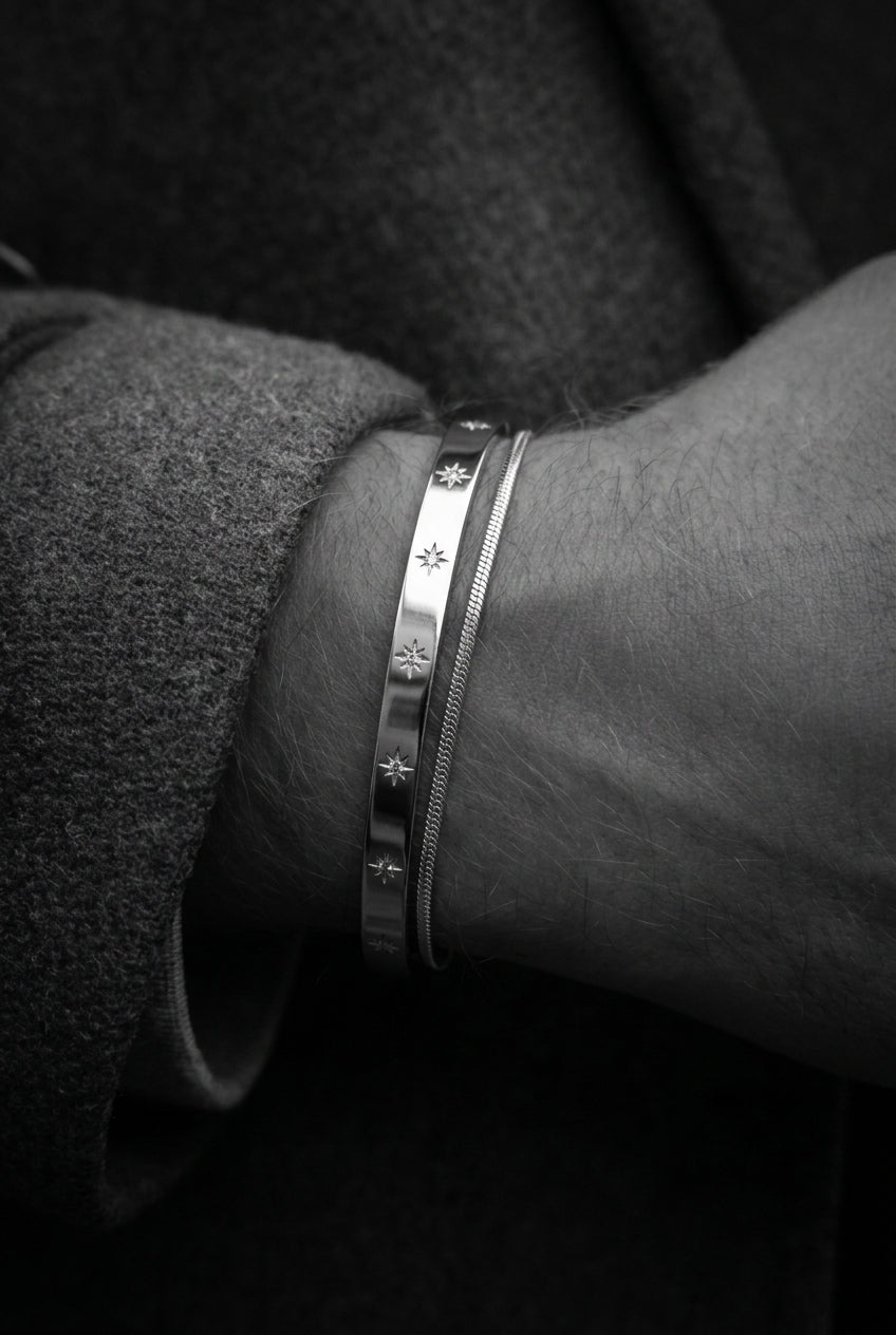 Close-up of a wrist wearing a silver bracelet with star designs.