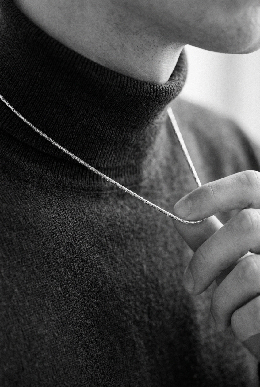 Person wearing a black turtleneck sweater with a blurred background