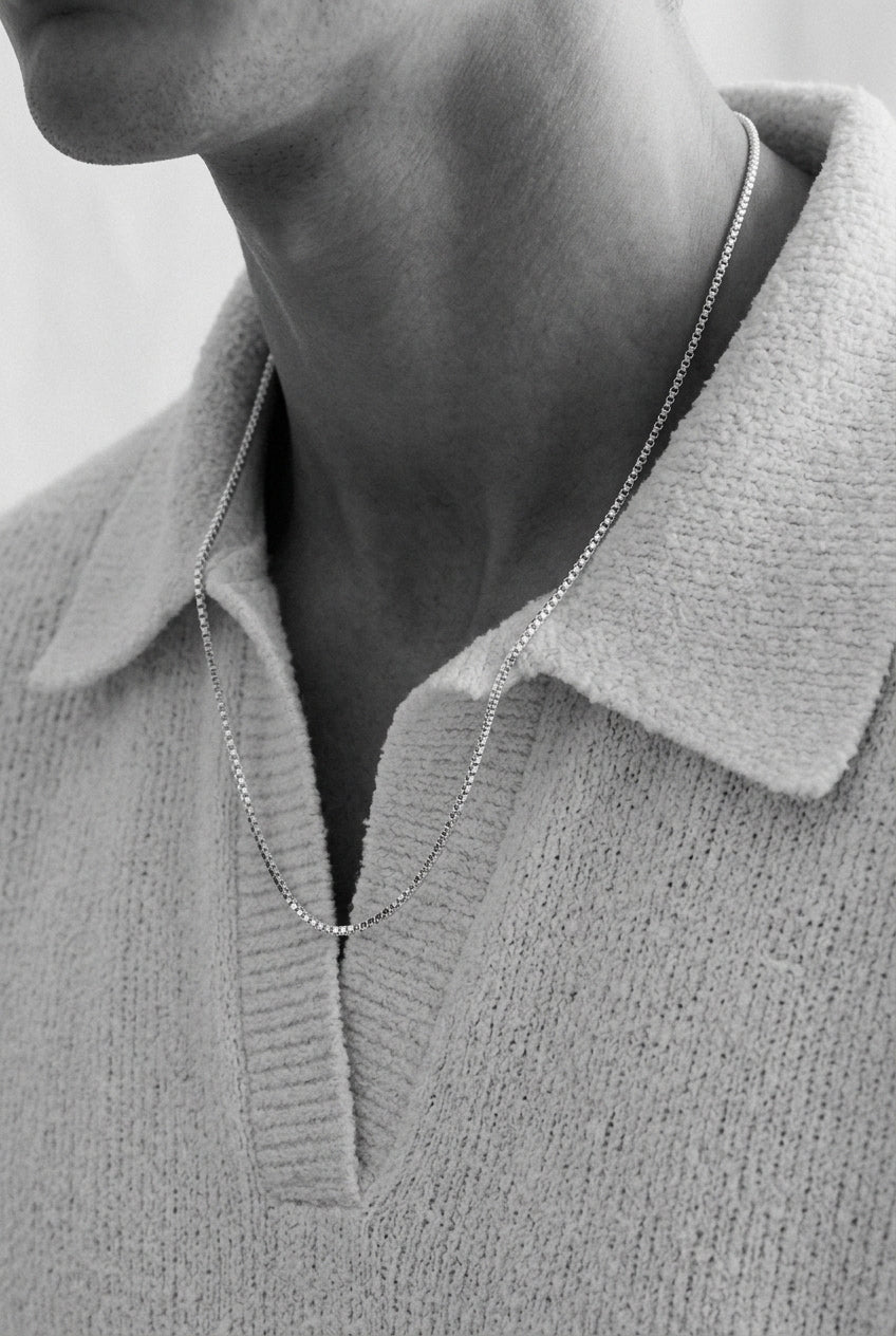 Close up photo of a mens neck with a necklace