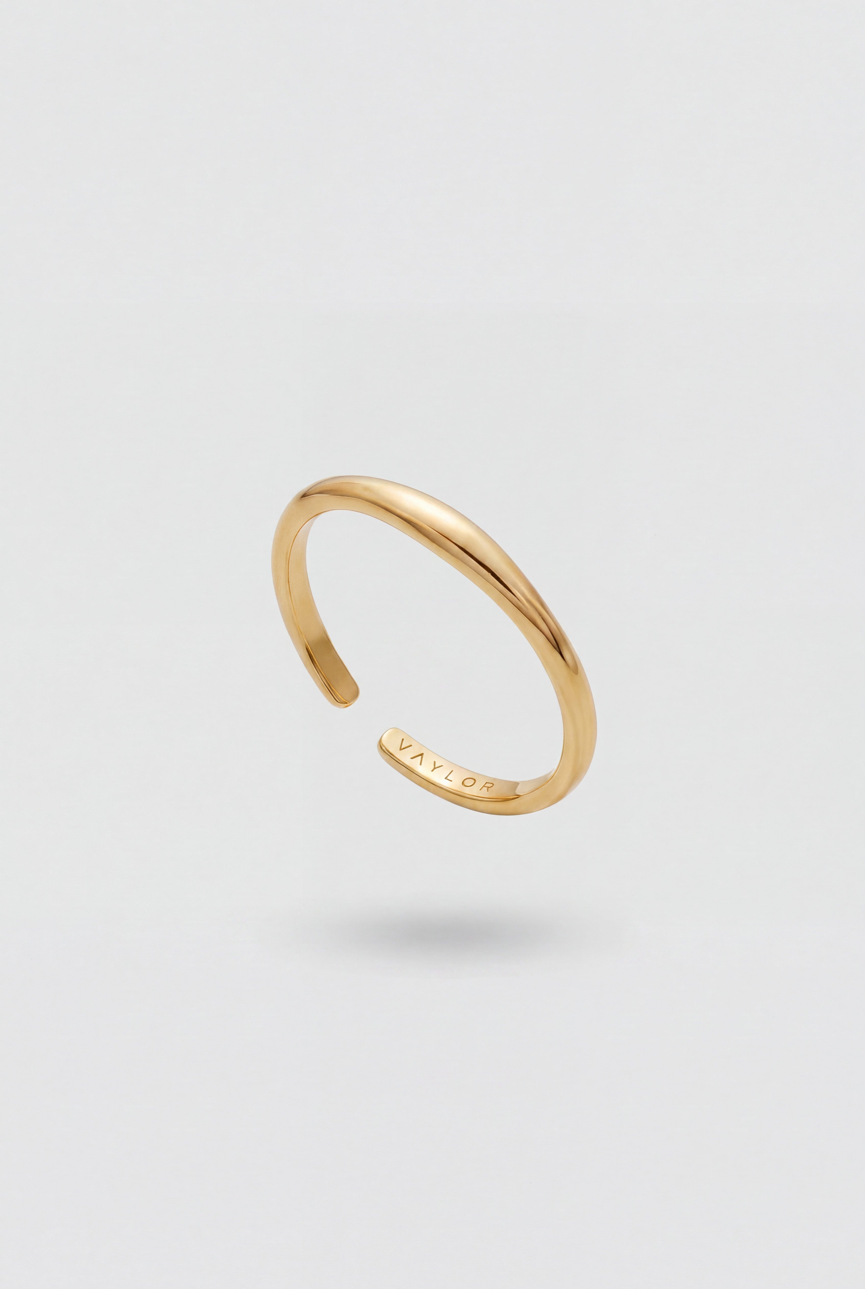 Gold open ring on a light gray background