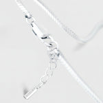 Silver bracelet with a tag on a light gray background