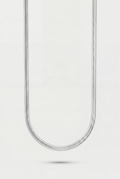 Silver chain necklace on a light gray background