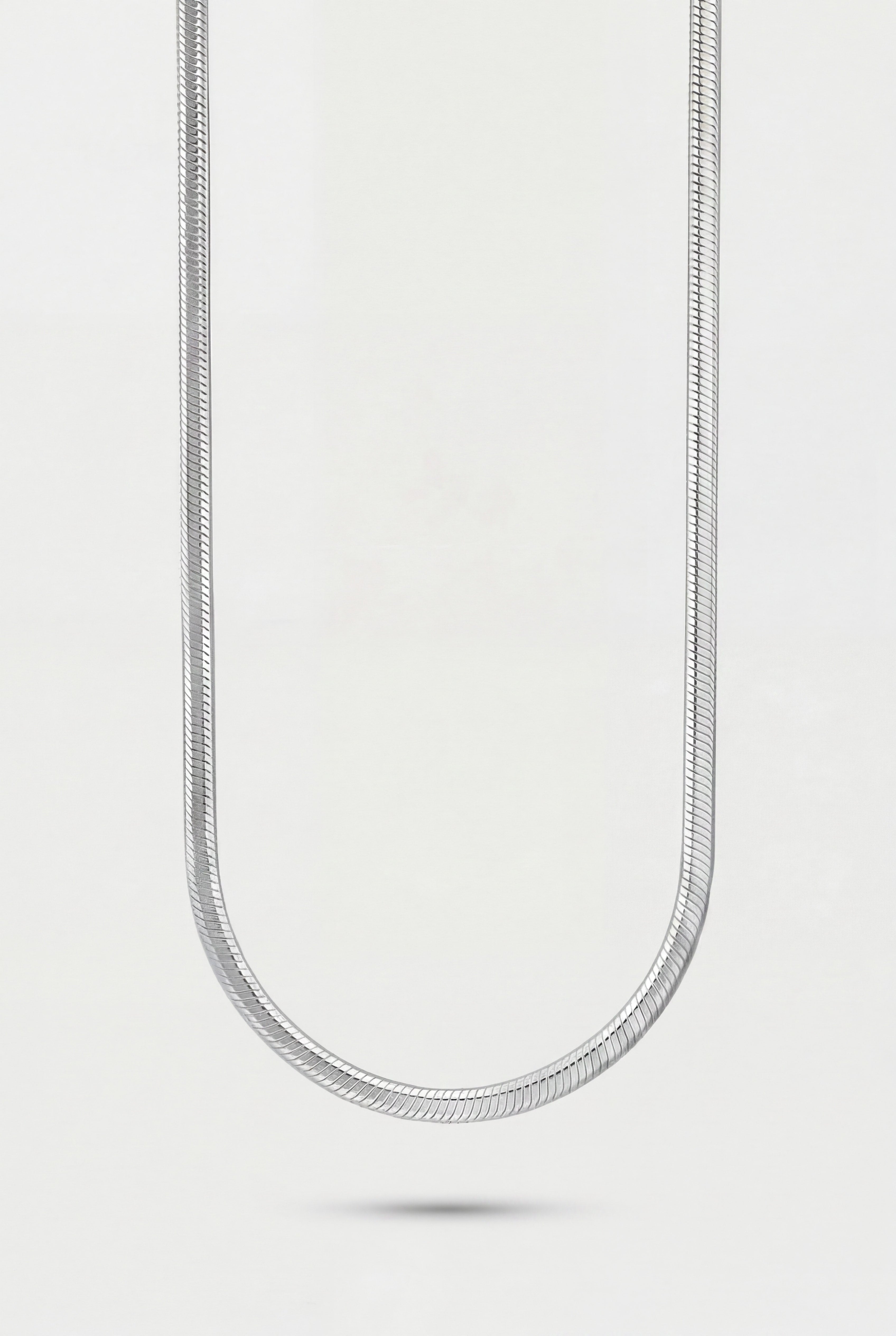 Silver chain necklace on a light gray background