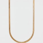 Gold chain necklace on a light gray background