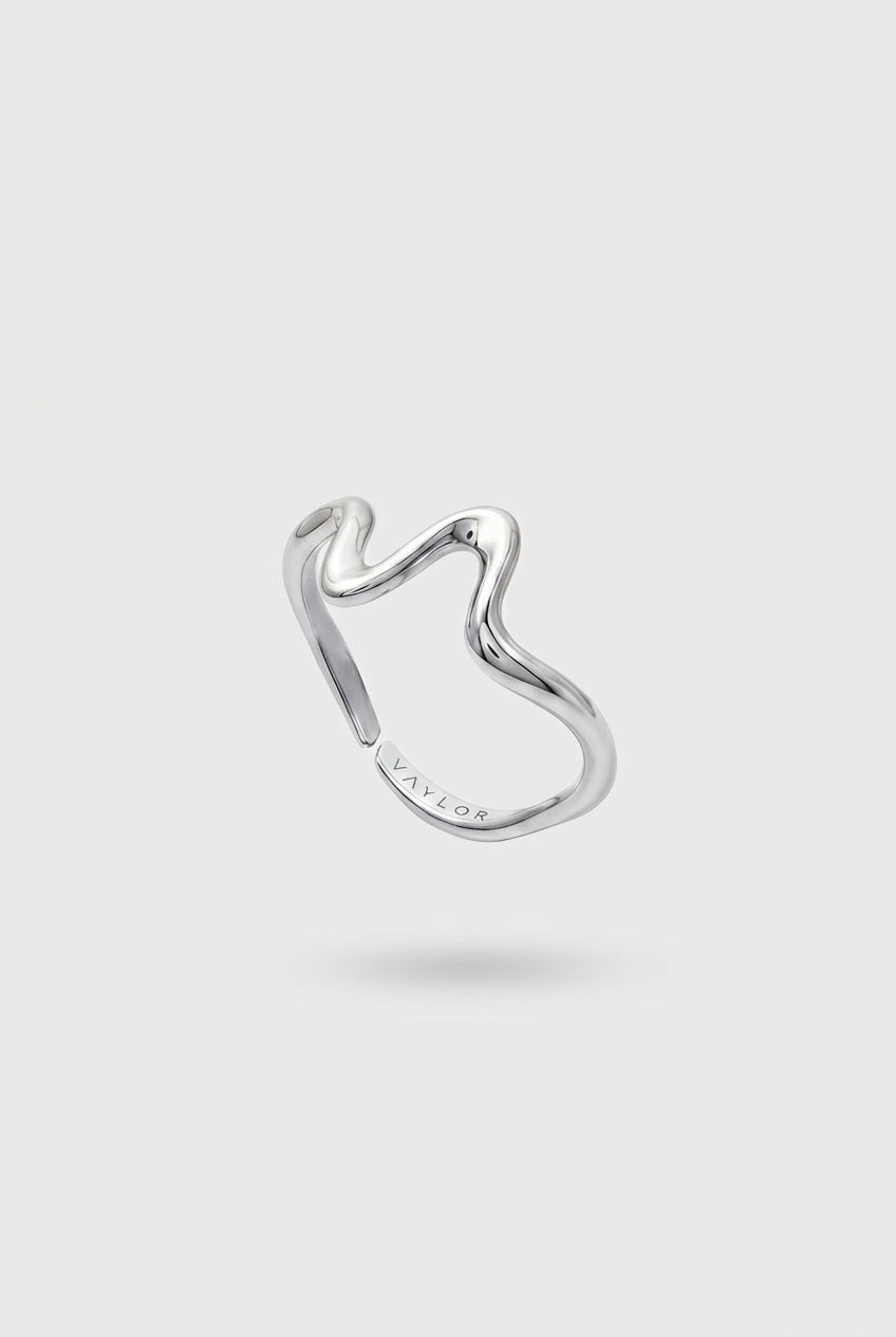 Silver wave shaped ring on a light gray background