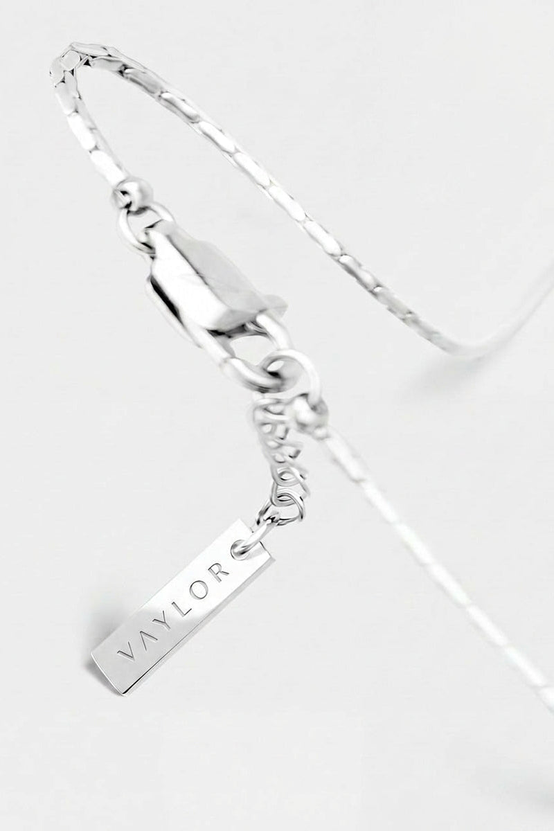 Silver bracelet with a name tag charm on a white background