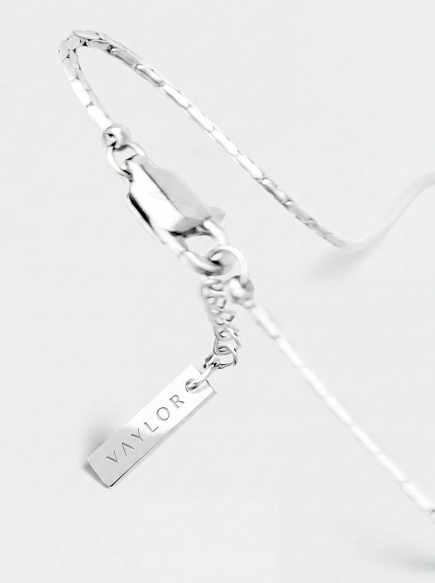 Silver bracelet with a name tag charm on a white background