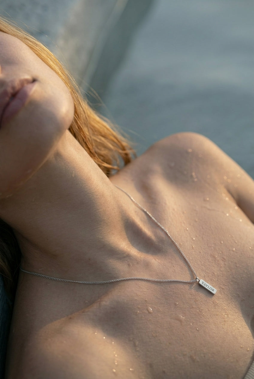 Women photo with a pendant necklace with VAYLOR engraving on it