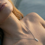 Women photo with a pendant necklace with VAYLOR engraving on it