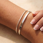 Womens arm with a cuff bangle and a bracelet in silver 